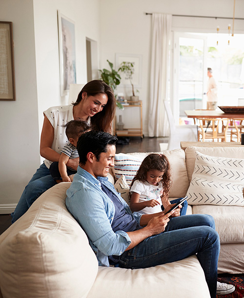 Family in the living room looking at a tablet or computer