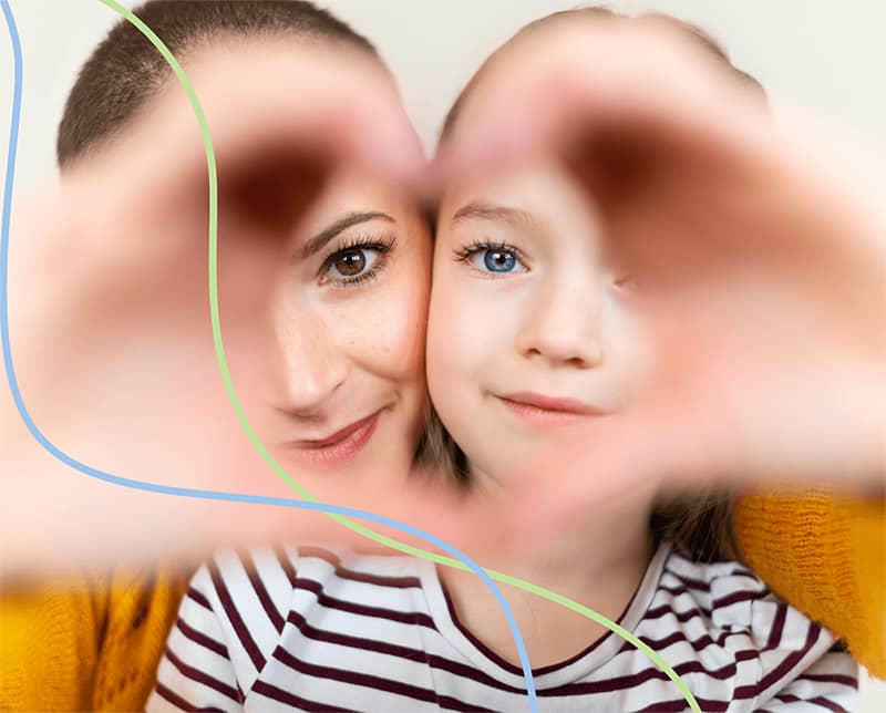 Mother and daughter with hands together in the shape of a heart